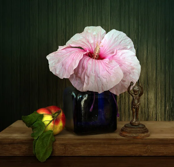 Una Flor Hibisco Jarrón Vidrio Azul Una Manzana Madura Una — Foto de Stock