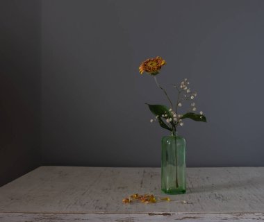 Düşen yapraklı küçük bir buket kurumuş çiçek. Minimalizm.