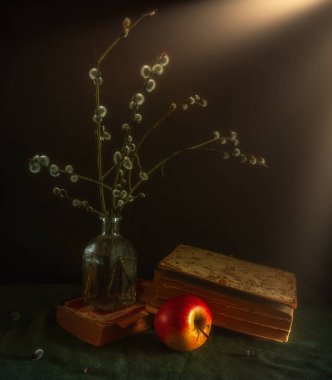 Çiçek açan söğüt dalları, eski kitaplar ve koyu arkaplanda olgun bir elmayla dolu bir hayat. Eski.