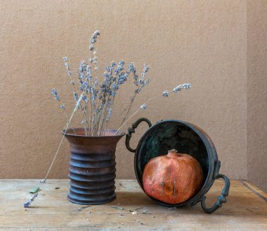 Olgun kırmızı nar, lavanta çiçekleri ve bakır çatal bıçaklarla dolu bir hayat. Eski.