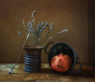 Olgun kırmızı nar, lavanta çiçekleri ve bakır çatal bıçaklarla dolu bir hayat. Eski.