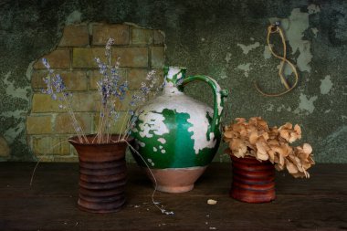 Çok eski bir seramik sürahi, kabuğu soyulmuş boya ve iki seramik vazo kurutulmuş çiçek. Eski.