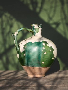 Çok eski bir seramik sürahi ve soyulmuş boya. Eski model. Minimalizm.