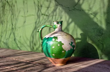 Çok eski bir seramik sürahi ve soyulmuş boya. Eski model. Minimalizm.
