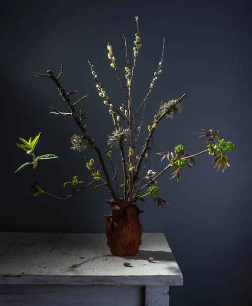 Spring bouquet of elder and pussy willow branches in a ceramic vase.