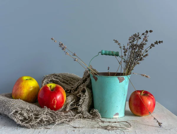 Çuval bezinde olgun elmalar ve kovada bir demet lavanta ile dolu bir hayat. Eski model. Retro.