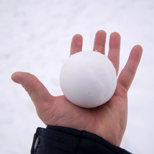Kula śnieżna w gołej ręce. kula śnieżna topi się gołymi rękami — Zdjęcie stockowe