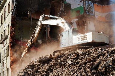 Kazıcı tuğla bir binayı yıkıyor. Makine Yıkım Binası