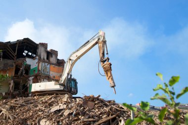 Kazıcı tuğla bir binayı yıkıyor. Makine Yıkım Binası.