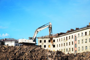 Kazıcı tuğla bir binayı yıkıyor. Makine Yıkım Binası.