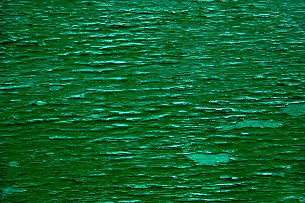 Pęknięte tło farby. Tło ścienne. Zbliżenie szczegółów popękanej farby na zielonej ścianie — Zdjęcie stockowe
