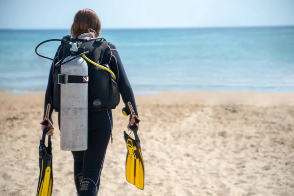 Nurek nurkowy. Nurek dziewczyna spacery wzdłuż plaży w kierunku morza — Zdjęcie stockowe