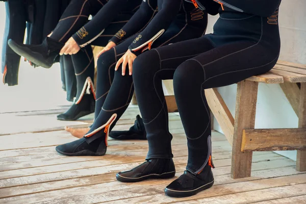 Duikers trekken een wetsuit aan en maken zich klaar om te duiken. Meisjesduiker — Stockfoto