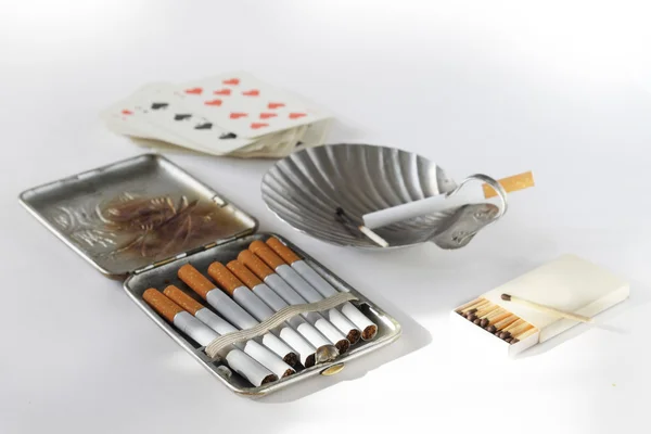 Still life with an ancient cigarette case, cigarettes and playing cards — Stock Photo, Image