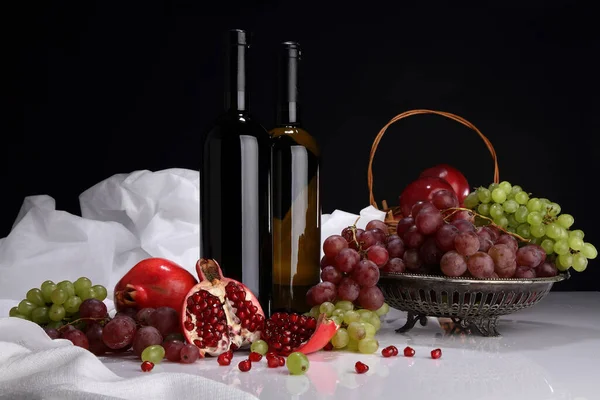 Botellas Vino Granadas Uvas Manzanas Sobre Una Mesa Blanca Brillante — Foto de Stock