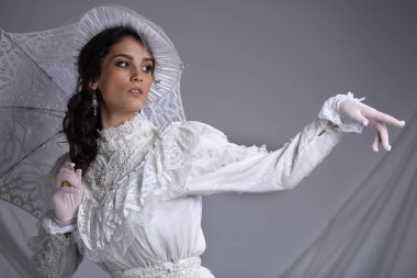 Portrait of a beautiful girl in a dress, hat with a veil and umbrella in retro style