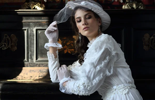 Portret Dziewczyny Białej Sukience Kapelusz Welonem Rękawiczkami Tle Fortepianu Stylu — Zdjęcie stockowe
