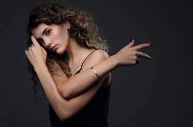 Stüdyo portresi, siyah bluzlu, siyah arka planda ince, güzel bir kız.