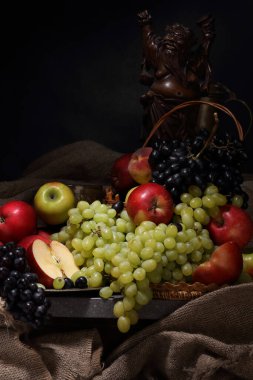 Üzümlü, elmalı ve antika ahşap bir ayyaş heykeli olan eski moda bir hayat.