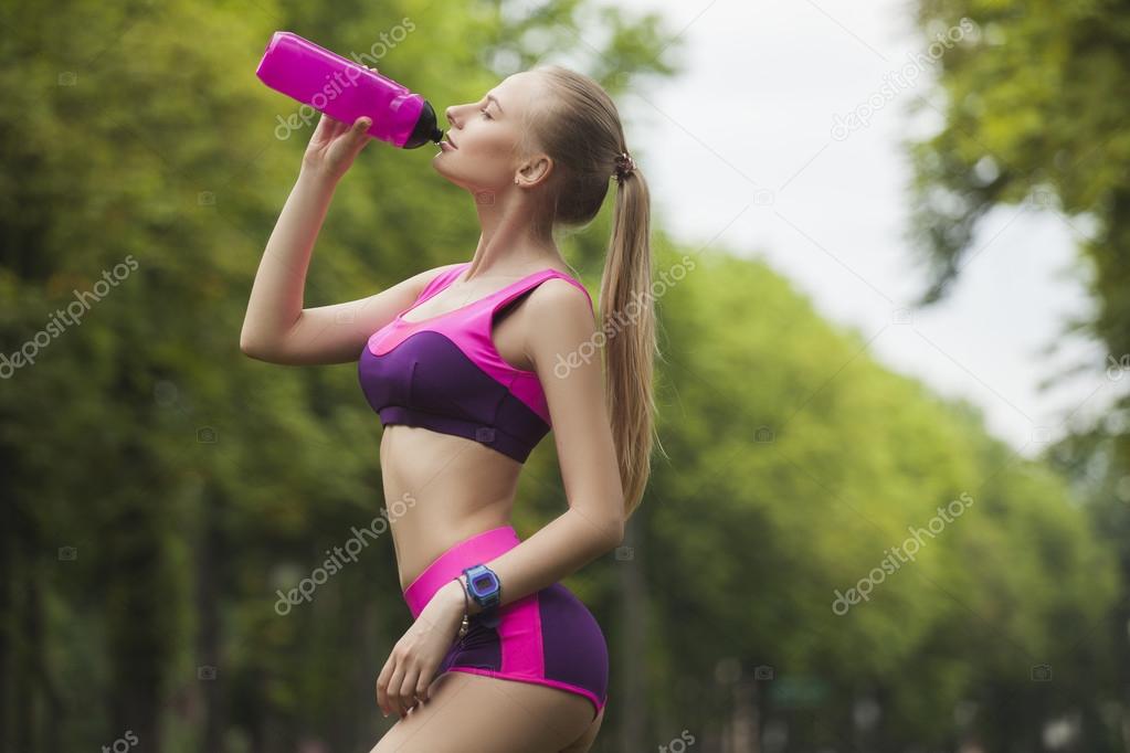 escena Catarata Abultar Sexy and sporty girl during the break, drinks water from the bottle Stock  Photo by ©StaceStock 116168610