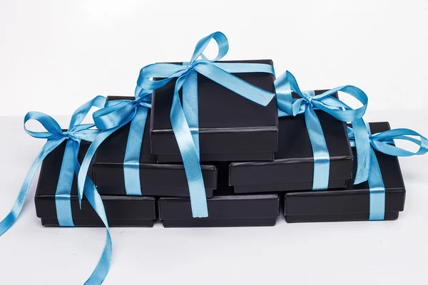 A pyramid of black boxes with blue bows — Stock Photo, Image