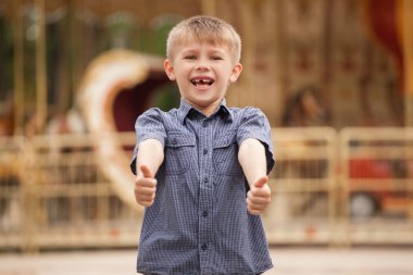 Çocuk gülüyor ve başparmak ortaya