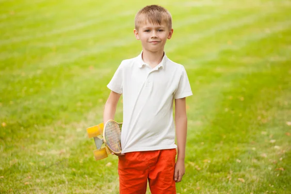 Junge steht mit Skateboard in der Hand — Stockfoto