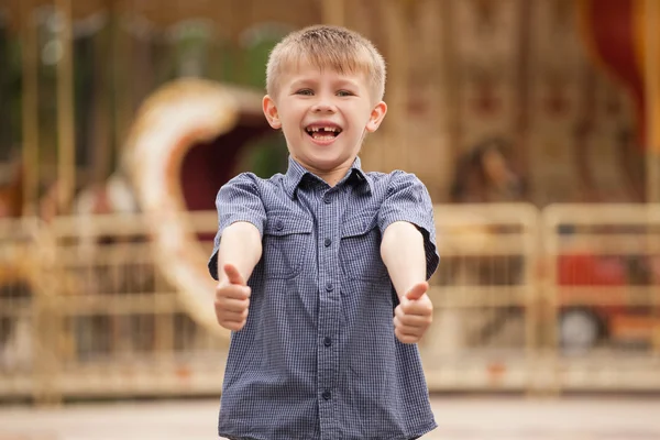 Çocuk gülüyor ve başparmak ortaya