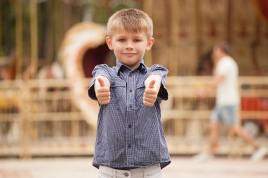 Çocuk gülümsedi ve ellerini ortaya koymak ve başparmak ortaya