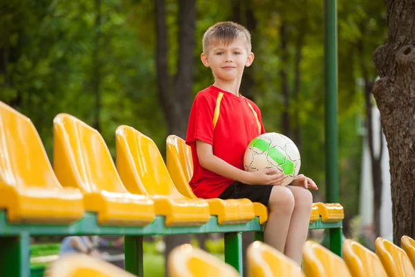 Chlapec s míčem na lavičce — Stock fotografie