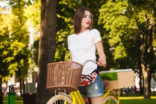 Fille sur un vélo avec un congélateur regardant vers le côté — Photo