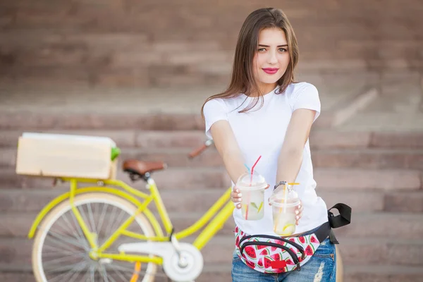 Mädchen hält einen Cocktail auf dem Hintergrund des Fahrrads — Stockfoto