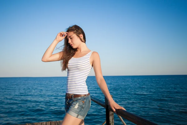 Mädchen, das auf der Seebrücke steht. schöner Meereshintergrund — Stockfoto