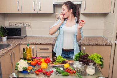 Kız ev mutfağında sebze ile eğleniyor