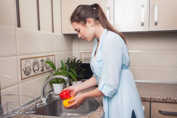 Meisje wassen van peper in eigen keuken — Stockfoto