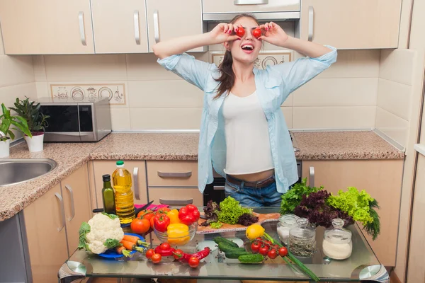 Dívka baví se zeleninou v domácí kuchyni — Stock fotografie