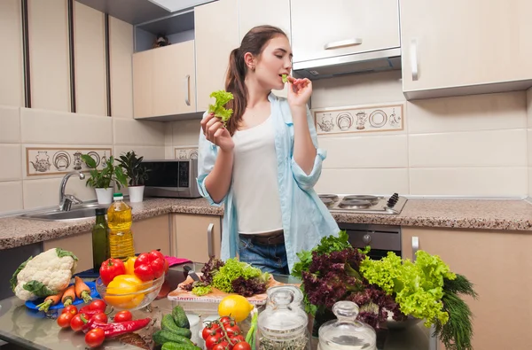 Diyet salata hazırlanması sırasında genç kız marul yiyor
