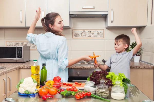 Mãe com a criança se divertindo na cozinha durante a preparação — Fotografia de Stock
