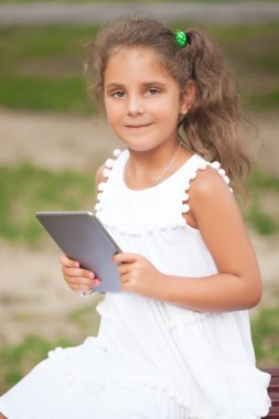 Bir tablet kullanan bir şirin kız portresi