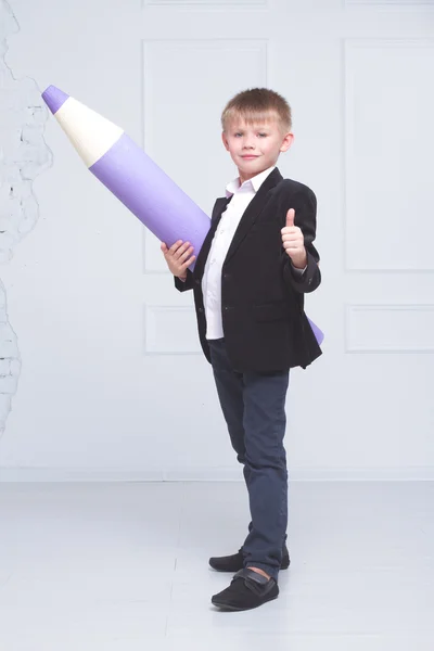 Chlapec ve školní uniformě stojí na pozadí velkého Penc — Stock fotografie