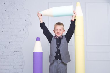 Büyük bir kalemle duran sevimli çocuk. Eğitim. 