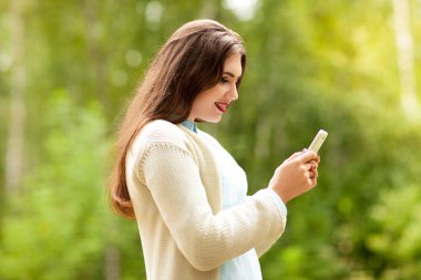  Beyaz ceketli güzel kız telefon ekranına bakar ve gülümsüyor