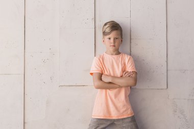 Şık çocuk duvara karşı duruyor. Sol tarafta yer