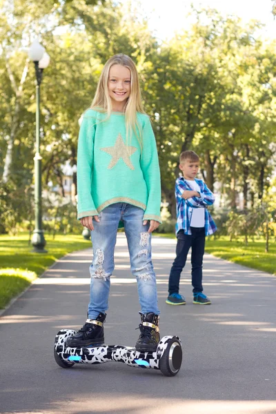 Na pierwszym planie dziewczyna w skuterze żyroskopu i w tle zdenerwowany chłopca — Zdjęcie stockowe