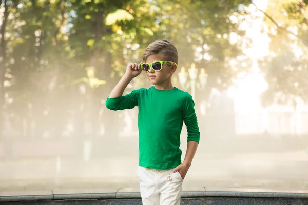 Petit garçon élégant dans des lunettes de soleil et des vêtements à la mode  . — Photo