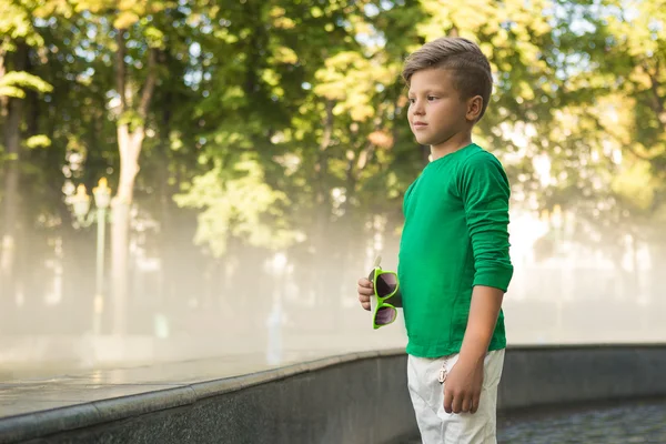 Stylový chlapec leží v rukou brýlí a dívá se na stranu. Místo pro text . — Stock fotografie