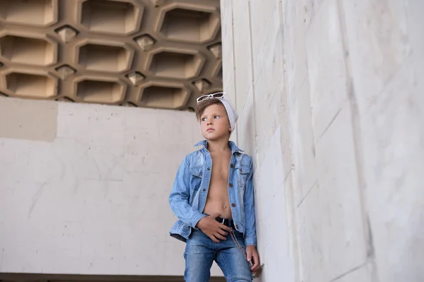세련된 소년은 벽에 기대어 측면을 찾고 . — 스톡 사진