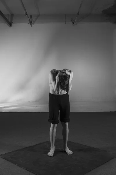 Young stong man dancing in the studio. Flexible body.Black and white.