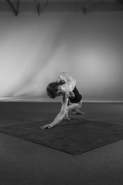 Young stong man dancing in the studio. Flexible body.Black and white. — Stock Photo, Image