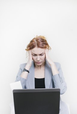 Stresli bir iş kadını ile onu laptop önünde oturan kafasına eller